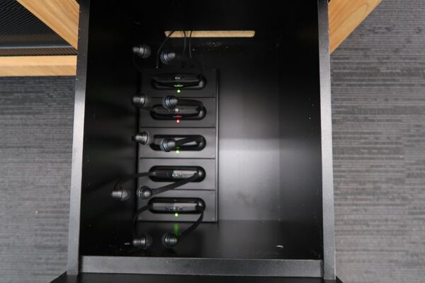 Pedestal - inside view of drawer showing assistive listening devices in charging base