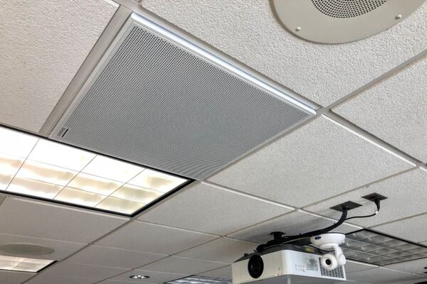 White 2 x 2 tile mounted in the ceiling to provide microphone coverage over student seating