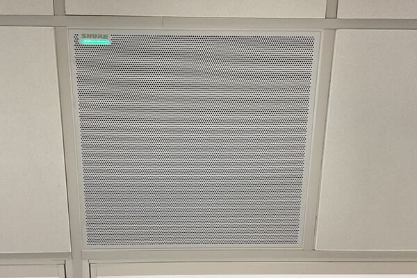 White 2x 2 tile mounted in the ceiling to provide microphone coverage over student seating