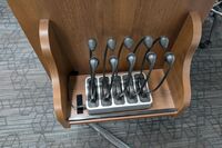 Pedestal - view showing assistive listening devices and microphones in charging base