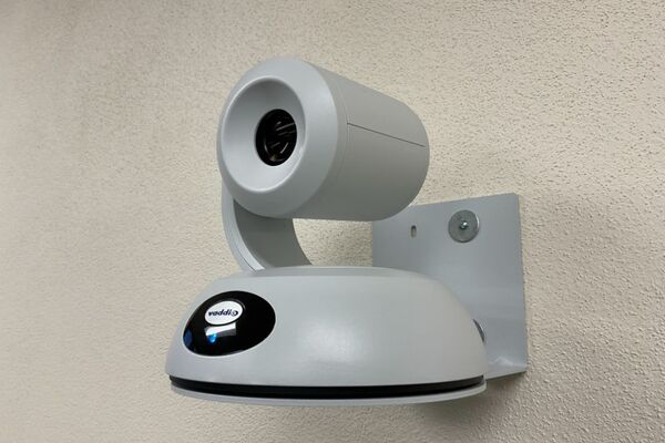 Camera mounted to a wall and instructor enabled adjustments to the lens to allow the instructor to be "seen" by the camera in more locations around the room