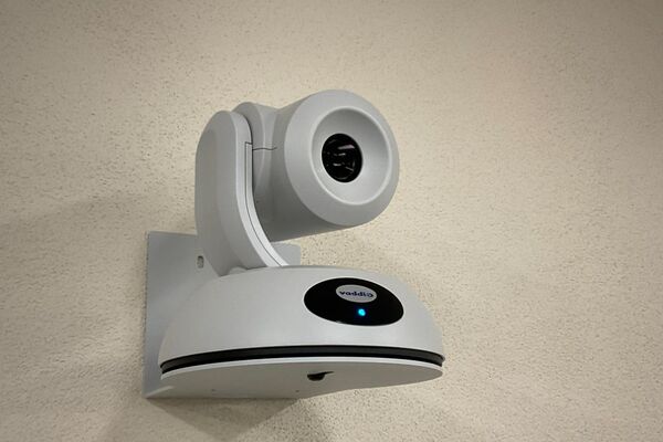 Camera mounted to a wall and instructor enabled adjustments to the lens to allow the instructor to be "seen" by the camera in more locations around the room
