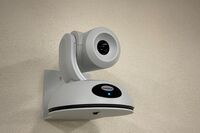 Camera mounted to a wall and instructor enabled adjustments to the lens to allow the instructor to be "seen" by the camera in more locations around the room