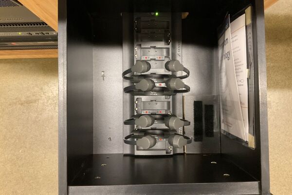 Pedestal - inside view of drawer showing assistive listening devices in charger