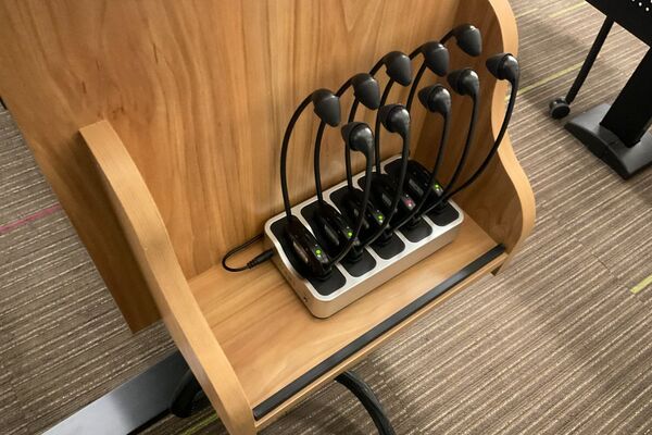  Pedestal - inside view of drawer showing two wireless mics in charging base and assistive listening devices in charger