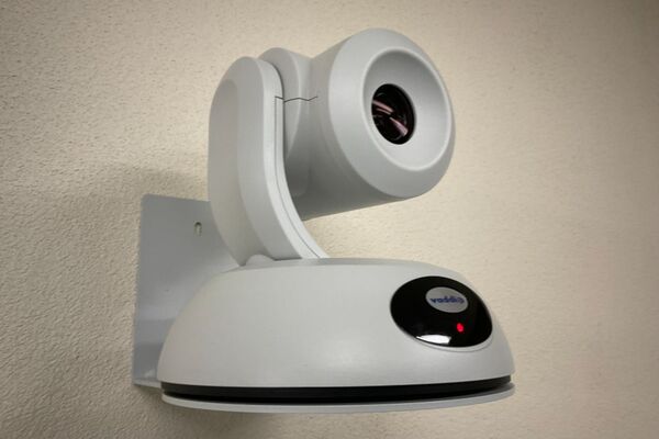 Camera mounted to a wall and instructor enabled adjustments to the lens to allow the instructor to be "seen" by the camera in more locations around the room