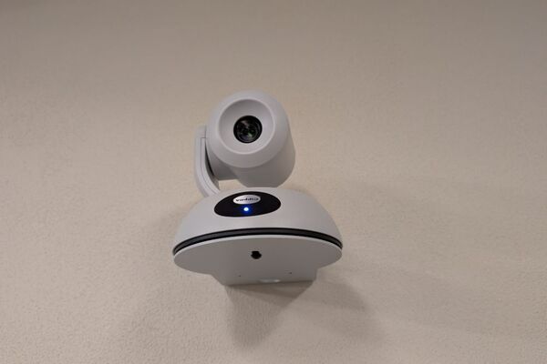 Camera mounted to a wall and instructor enabled adjustments to the lens to allow the instructor to be "seen" by the camera in more locations around the room