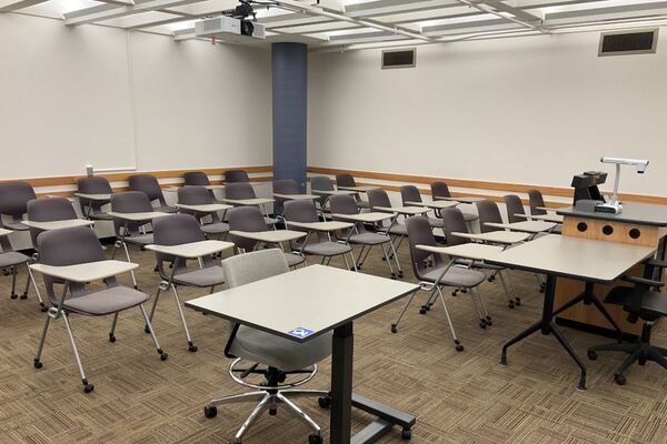 Rear of room view of student tablet arm chair seating on casters