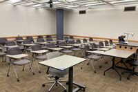 Rear of room view of student tablet arm chair seating on casters