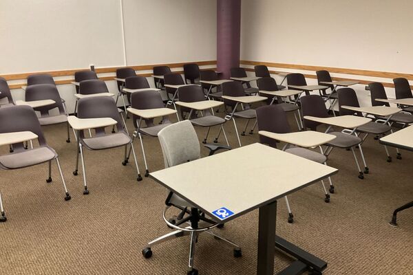 Rear of room view of student tablet arm chair seating on casters