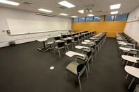 Front of room view with lectern on right in front of markerboard 
