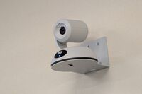 Camera mounted to a wall and instructor enabled adjustments to the lens to allow the instructor to be "seen" by the camera in more locations around the room