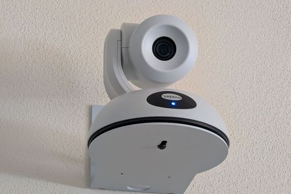 Camera mounted to a wall and instructor enabled adjustments to the lens to allow the instructor to be "seen" by the camera in more locations around the room