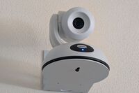 Camera mounted to a wall and instructor enabled adjustments to the lens to allow the instructor to be "seen" by the camera in more locations around the room