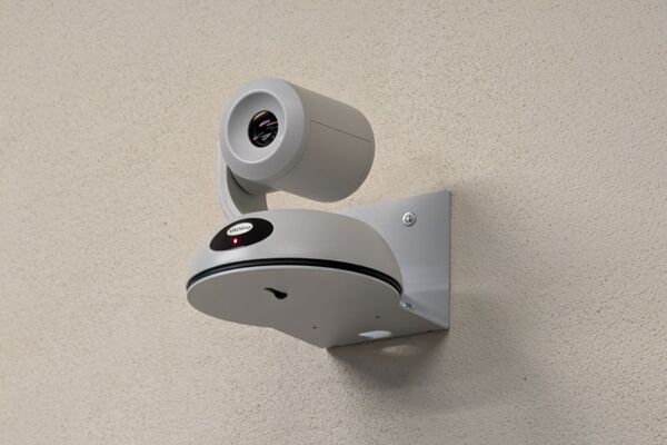 Camera mounted to a wall and instructor enabled adjustments to the lens to allow the instructor to be "seen" by the camera in more locations around the room