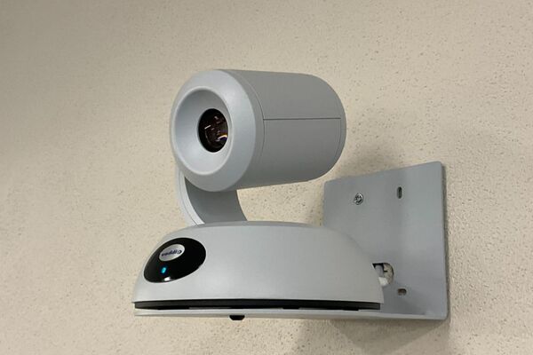 Camera mounted to a wall and instructor enabled adjustments to the lens to allow the instructor to be "seen" by the camera in more locations around the room