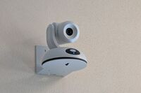 Camera mounted to a wall and instructor enabled adjustments to the lens to allow the instructor to be "seen" by the camera in more locations around the room