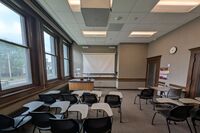 Front of room view with lectern on left in front of markerboard 