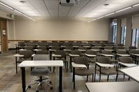 Back of room view of student tablet arm seating and exit door at rear left of room