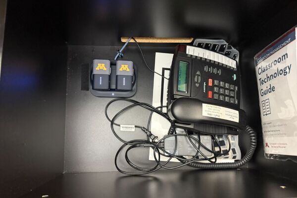 Pedestal - inside view of drawer showing telephone and two wireless mics in charging base 