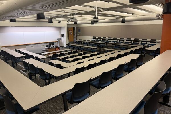 Front of room view with lectern center in front of markerboard and exit door to right