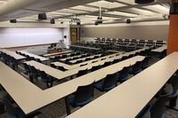 Front of room view with lectern center in front of markerboard and exit door to right