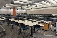 Back of room view of student fixed table and chair seating