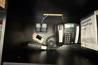 Pedestal - inside view of drawer showing two wireless mics in charging base and telephone