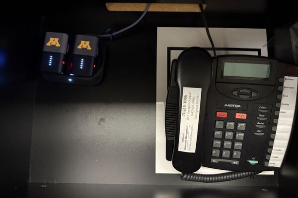 Pedestal - inside view of drawer showing two wireless mics in charging base and telephone