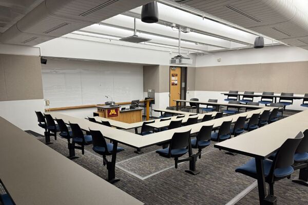 Front of room view with lectern center in front of markerboard and exit door to the front right