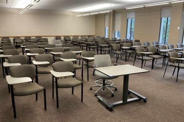 Back of room view of student tablet arm seating and exit door on left wall of room