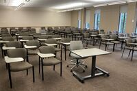 Back of room view of student tablet arm seating and exit door on left wall of room