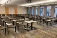 Back of room view of student tablet arm seating and double exit door at left rear of room