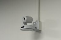 Camera mounted to a wall and instructor enabled adjustments to the lens to allow the instructor to be "seen" by the camera in more locations around the room