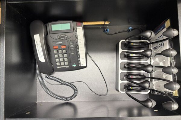 Pedestal - inside view of drawer showing assistive listening devices in charger