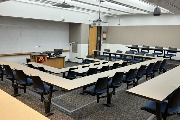 Front of room view with lectern center in front of markerboard and exit door front right