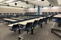 Back of room view of student tiered fixed table and chair seating 