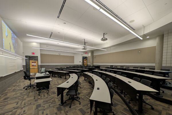 Back of room view of student tiered fixed-table and chair seating 