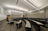 Back of room view of student tiered fixed-table and chair seating 
