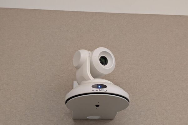 Camera mounted to a wall and instructor enabled adjustments to the lens to allow the instructor to be "seen" by the camera in more locations around the room