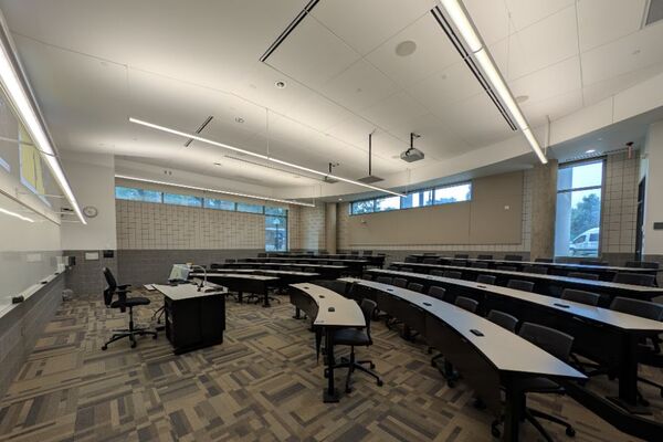 Back of room view of student tiered seating with fixed-tables and chairs