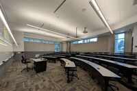 Back of room view of student tiered seating with fixed-tables and chairs