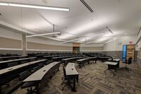 Back of room view of student tiered fixed-table and chair seating 