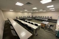 Back of room view of student tiered fixed table and chair seating