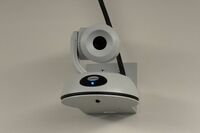 Camera mounted to a wall and instructor enabled adjustments to the lens to allow the instructor to be "seen" by the camera in more locations around the room