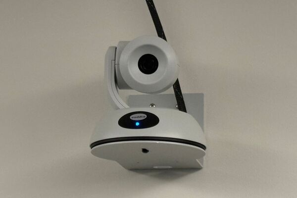 Camera mounted to a wall and instructor enabled adjustments to the lens to allow the instructor to be "seen" by the camera in more locations around the room
