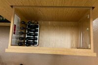Pedestal - inside view of drawer showing wireless mics in charging base and assistive listening devices in charger