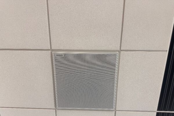 White 2 x 2 tile mounted in the ceiling to provide microphone coverage over student seating