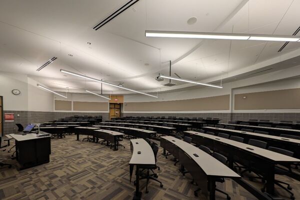 Back of room view of student tiered fixed-table and chair seating 