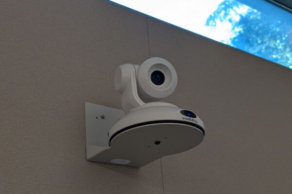Camera mounted to a wall and instructor enabled adjustments to the lens to allow the instructor to be "seen" by the camera in more locations around the room
